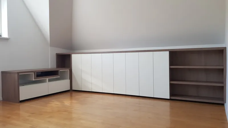 Vgrajena omara pod poševnim stropom z belimi vrati