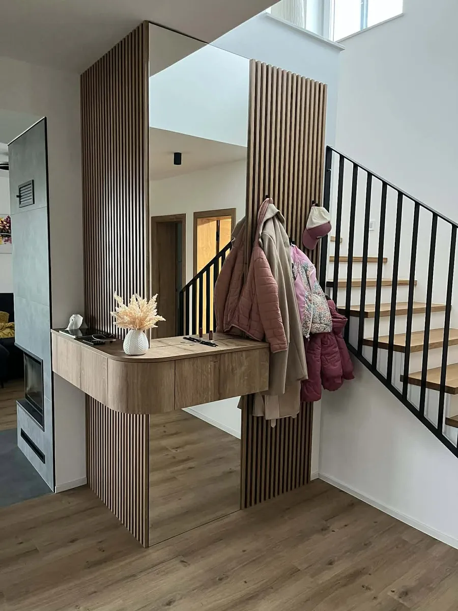 Custom entryway with slatted wood panels and floating shelf