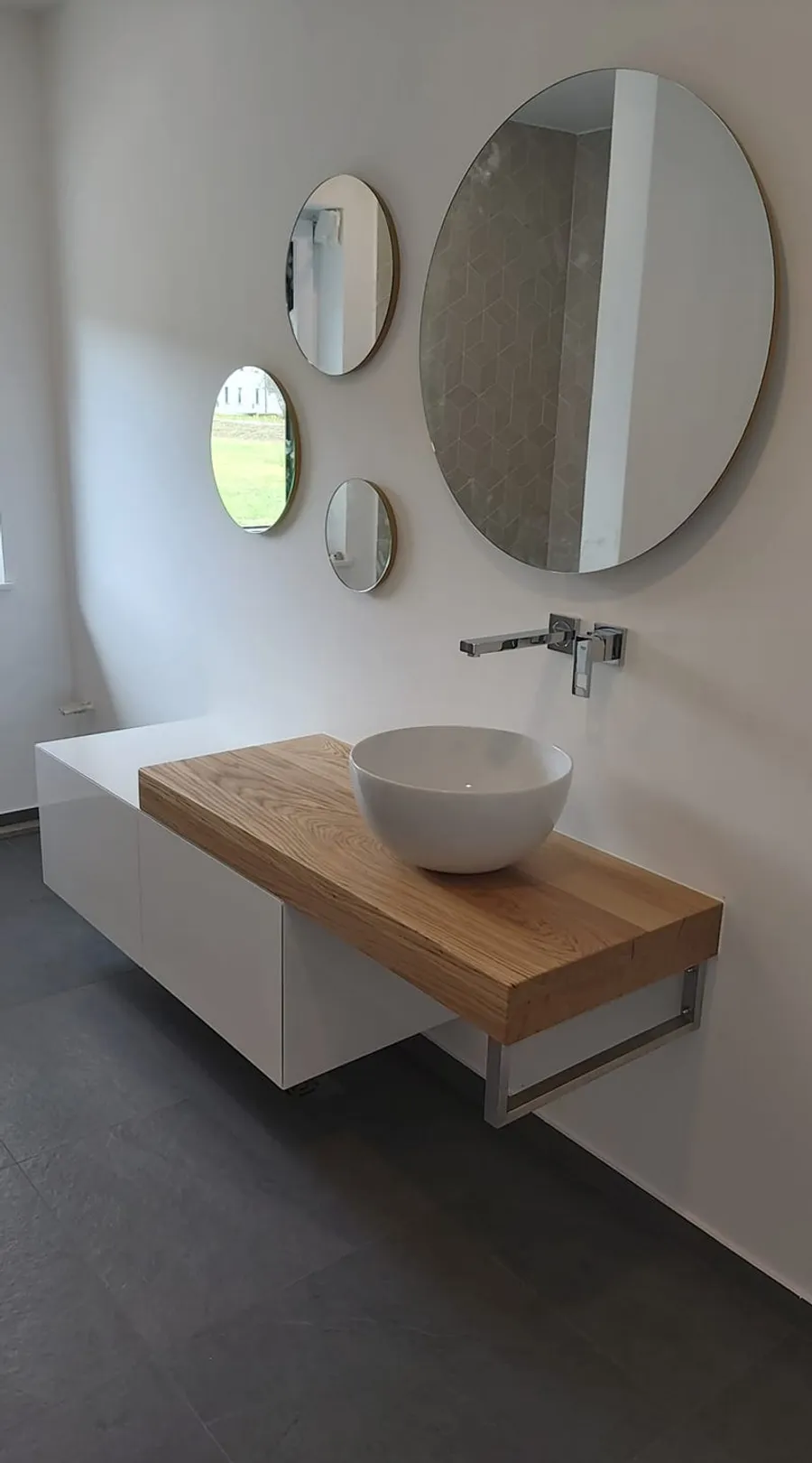 Bathroom vanity with oak shelf and round mirrors